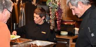 Sheila and Tim serving guest at traditional catering event