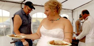 Bride holding plates of catered food at wedding event