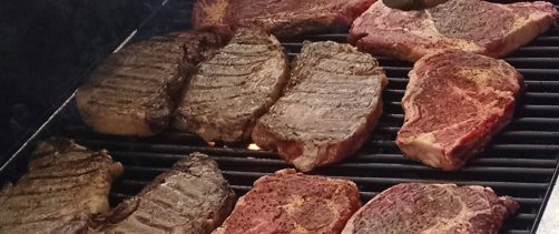 Steaks cooking on a grill