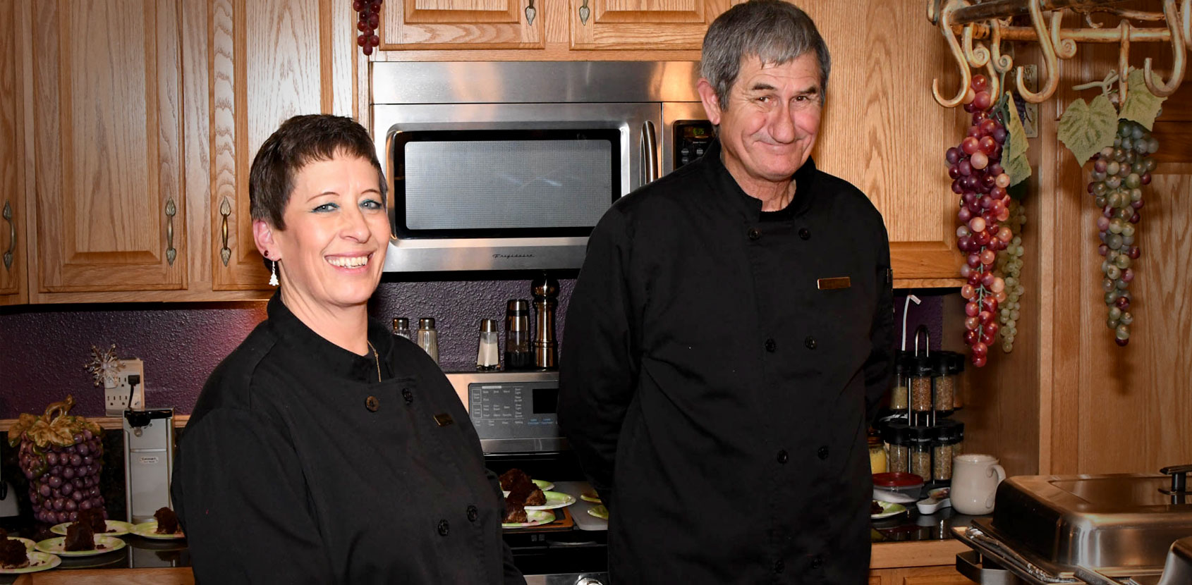 Old West Dutch Oven Catering Company owners Sheila and Tim Nold posing for camera in formal chef's attire